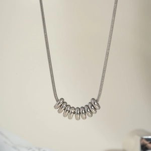 Minimalist silver stainless steel necklace featuring sleek metal beads and snake chain