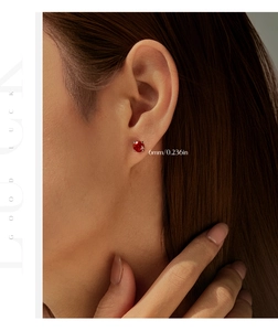 Close-up of 6mm red octagon rose-cut stud earring worn by a model in soft lighting