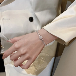 Close-up of a silver-toned adjustable bracelet with crystals on a woman's wrist