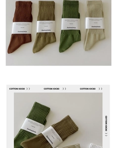 Detail von vier Paar gerippten Baumwollsocken in Erdtönen mit Papierbanderolen