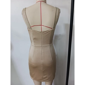 Detail of champagne satin evening dress featuring rhinestone straps and backless design