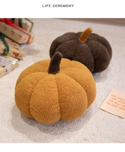 Detail of yellow and brown pumpkin plush pillows on a cozy carpet with gift box