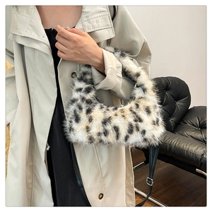 Close-up of fluffy leopard print plush crescent bag paired with a beige trench coat