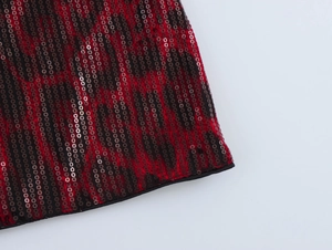 Gros plan détaillé sur la texture des paillettes rouges et noires avec bordure noire du vêtement