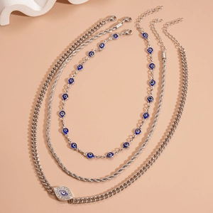 Detail of silver layered necklaces featuring evil eye pendants and rhinestone accents