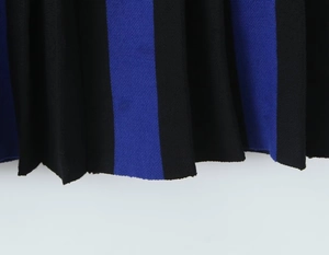 Λεπτομερής λήψη από μπλε και μαύρο ριγέ πλεκτό ύφασμα με πλισέ υφή και τελείωμα