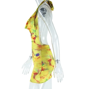 Detail of yellow halter neck mini dress with colorful abstract print and bodycon fit
