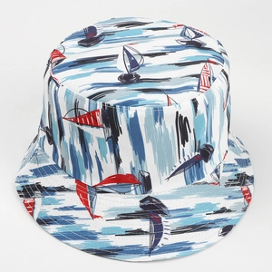 Detail shot of a reversible sun hat featuring colorful nautical sailboat prints on white canvas