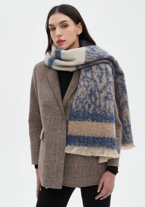 Detail of leopard print patchwork scarf with knit texture and fringed edges on model