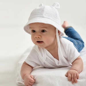 Close-up of white cotton baby sun hat with cute bunny ears and adjustable chin strap