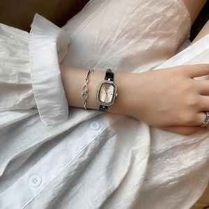 Nahaufnahme der eleganten Damen-Rechteckuhr mit Diamantlünette und schwarzem Lederband