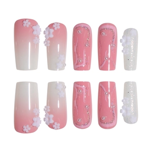 Pink gradient press-on nails with 3D white flowers, pearls, and silver glitter lines