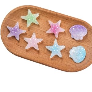 Glitter resin starfish and seashell accessories on oval wooden tray for DIY crafts