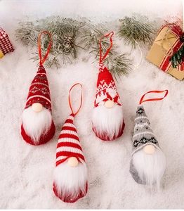 Set of four knitted Christmas gnomes with ribbons on a festive snowy background