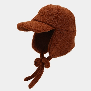 Close-up of brown lamb wool trapper hat with earflaps and soft fleece texture