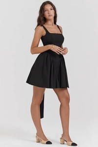 Detail eines eleganten schwarzen Minikleides mit eckigem Ausschnitt und Faltenwurf