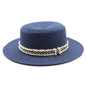 Détail du chapeau de paille marine avec ruban damier et bordure à franges