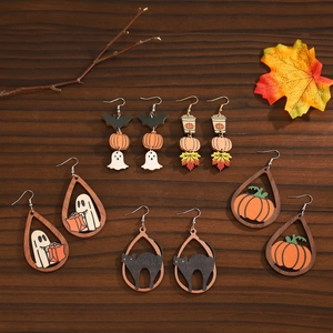 Halloween wooden earrings set with pumpkin, ghost, and cat motifs on autumn leaf background