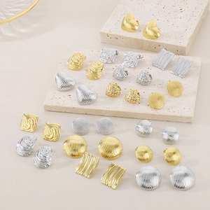 Detailansicht von Herz- und geometrischen Ohrringen mit Gold- und Silberoberflächen