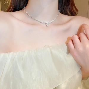 Close-up of model wearing a zircon and pearl necklace with a silver finish link chain