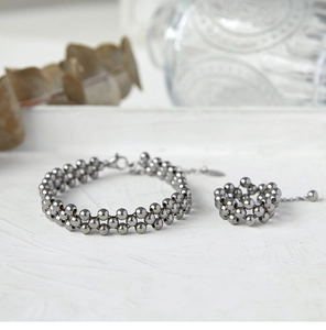 Detail of beaded 18K gold-plated stainless steel multi-layer bracelet and ring set