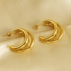 Polished 18K gold-plated multilayer C-shape hoop earrings on elegant champagne silk fabric