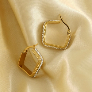 Elegant gold square hoop earrings with Greek key pattern and crystals on silk background