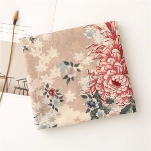 Detailed macro view of vintage cotton linen scarf with red chrysanthemum and maple leaf patterns