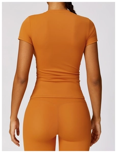 Detail of high-elasticity orange yoga set showing slim fit and waist support design