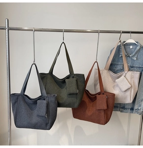 Detail of woven fabric tote bags in dark grey, green, caramel, and cream with matching pouches