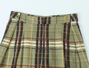 Détail de la taille et de la texture du tissu du pantalon en lin à carreaux verts