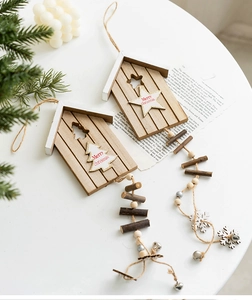 Detail of wooden Christmas ornaments featuring mini houses and bells in a cozy decor