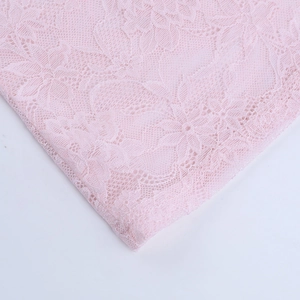 Primer plano de tela de encaje floral rosa que muestra la textura de malla delicada