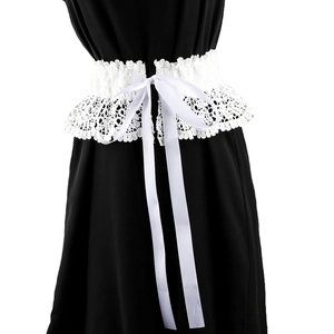 Detail of white lace corset belt featuring elegant satin ribbon bow on black dress