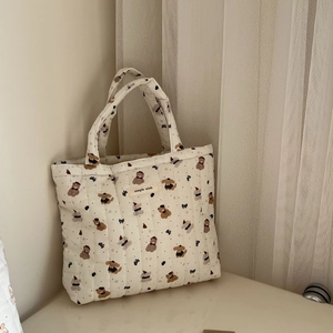 Close-up of quilted cotton tote bag featuring cute cartoon bear and puppy patterns