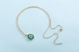 Detailed macro view of gold Libra zodiac necklace with green malachite and crystals