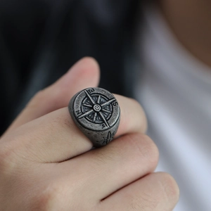 Macro shot of vintage compass signet ring in silver stainless steel on model's finger