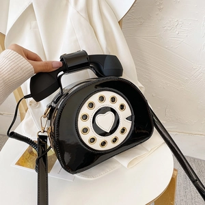 Detailed view of creative retro telephone shaped crossbody bag in black patent leather