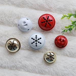 Festive hollow star and snowflake patterned Christmas bells on white faux fur background