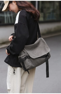 Side view of dark gray canvas messenger bag showing adjustable strap and storage details