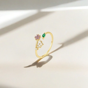 Macro detail of gold adjustable heart floral ring with purple and green zircon stones