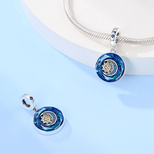 Vista macro del pendente sole e luna con cristalli blu e zircone giallo su charm in argento