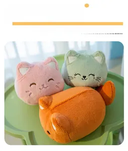 Detailed close-up of cute plush cat head keychains in pink, green, and orange colors