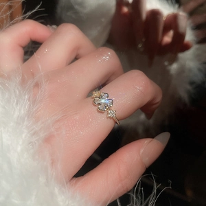 Close-up of elegant gold flower ring with zircon inlay worn on a model hand