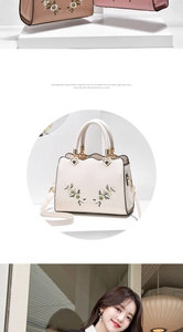 Detail of floral embroidery and heart-shaped metal zipper on women's soft leather tote bag
