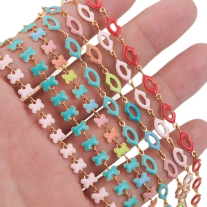 Golden stainless steel chains with colorful enamel butterfly and lip charms in hand