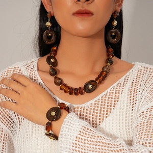 Detail shot of vintage acrylic amber bead jewelry set with gold metal accents