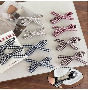Detail view of colorful plaid fabric bow hair clips with metal duckbill clip closure