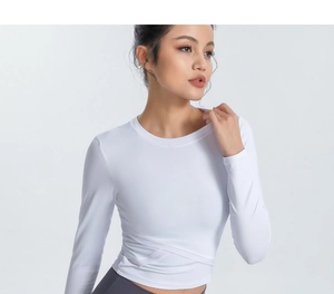 Détail du haut de yoga blanc à manches longues avec un design d'ourlet croisé unique
