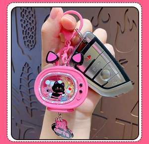 Pink cat TV keychain with liquid quicksand and glitter shown in hand